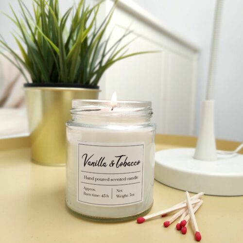 vela encendida con unas cerillas al lado. Está encendida sobre una mesa.