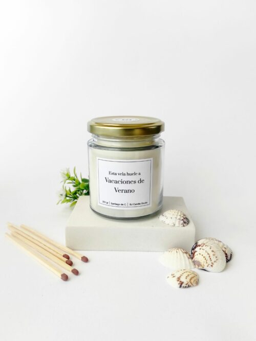 Vela aromática natural, rodeada de elementos como conchas y hojas