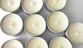 Vista superior de varias velas pequeñas en lata, todavía con las mechas sin recortar