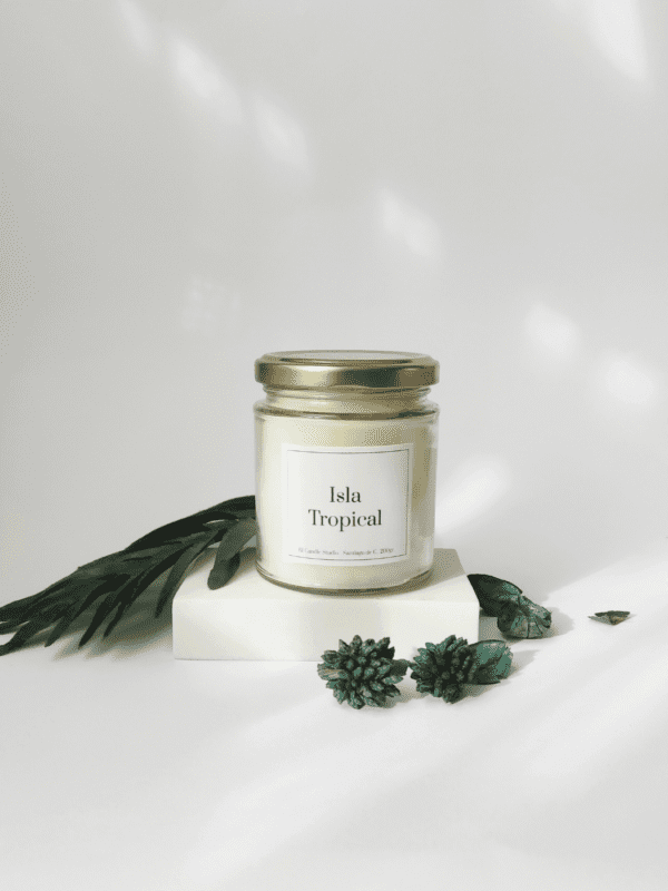 Vela artesanal Isla Tropical decorada con hojas de palmera y unos elementos verdes, aroma veraniego y diseño natural.