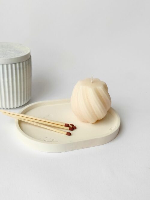 Bandeja minimalista de cemento blanco con una vela y cerillas, ideal para crear un rincón acogedor