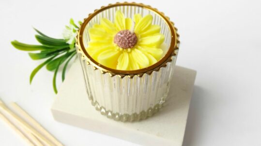 vela artesanal con una flor amarilla