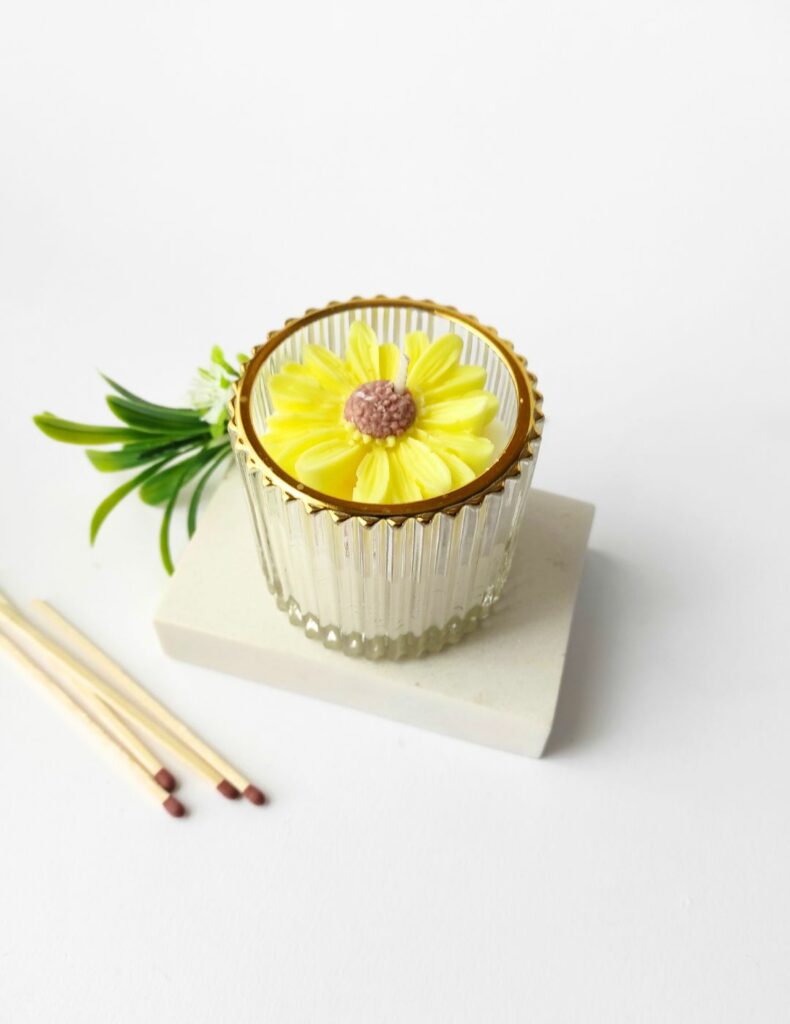 vela artesanal con una flor amarilla