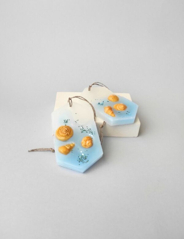 dos ambientadores de cera para armario con fragancia fresca a blue sea. Simulan la orilla del mar con conchas de cera dorada.