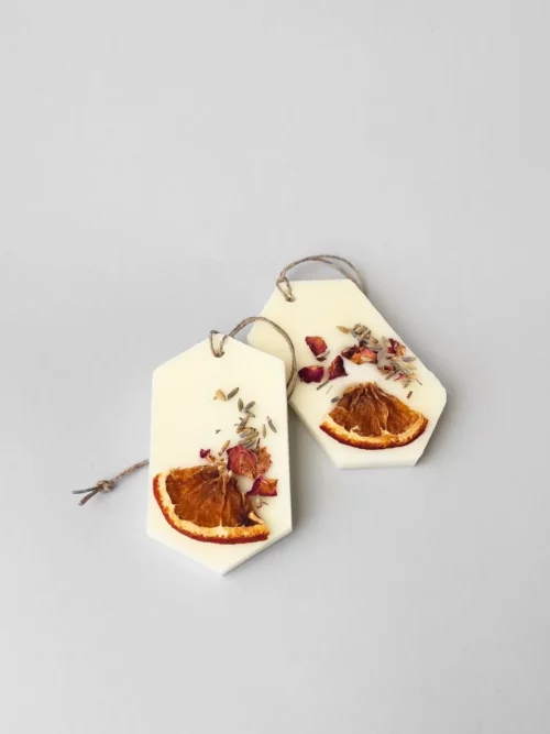 Dos ambientadores con olor a Lemon Fig, están hechos a mano con cera natural y decorados con naranja deshidratada, lavanda y pétalos de rosa