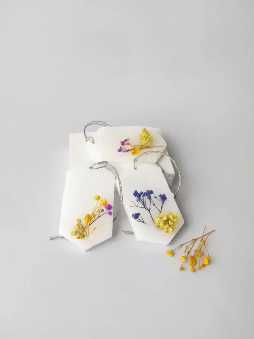 trío de ambientadores sólidos decorados con pequeñas flores secas en tonos amarillo y azul.
