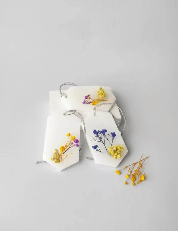 trío de ambientadores sólidos decorados con pequeñas flores secas en tonos amarillo y azul.