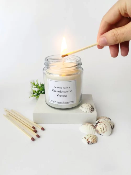 vela aromática de verano con una mano encendiéndola con una cerilla