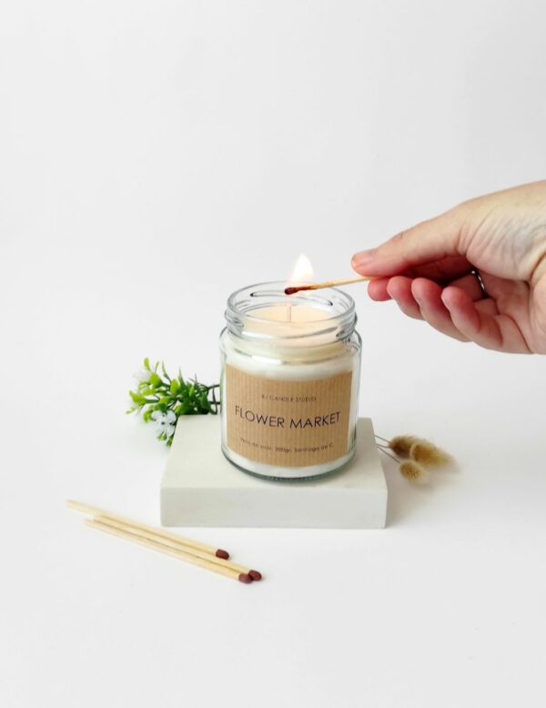 vela con aroma floral y hecha a mano con cera de soja en tarro de cristal y etiqueta kraft.